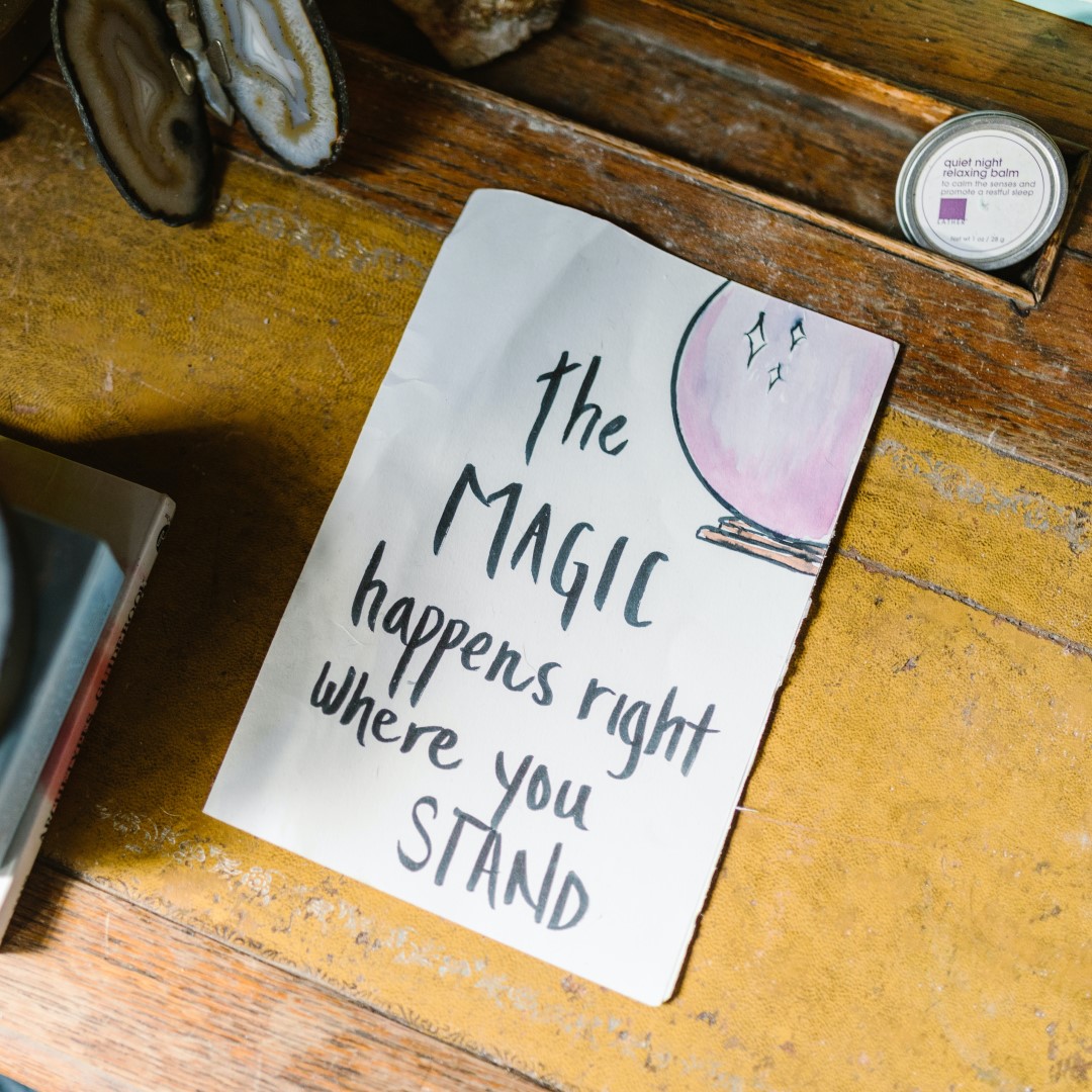 hand writing on paper saying "the magic happens right where you stand"