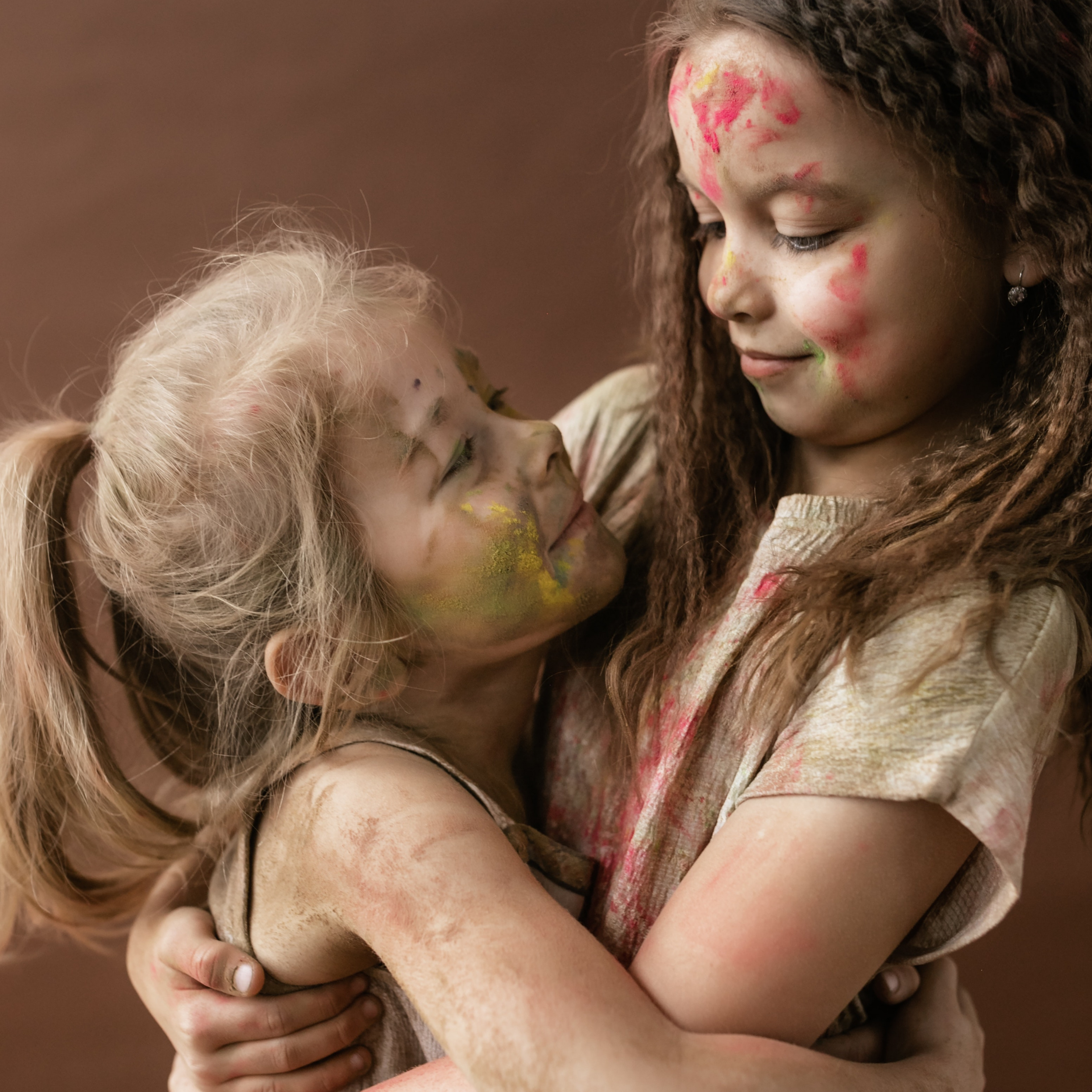 sisters with face painting hugging